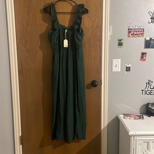 This is a dark green pantsuit, never worn had ruffled shoulder covers.